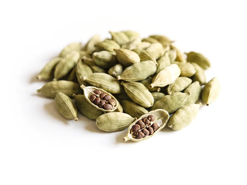 A small heap of green cardamom pods, two split open
